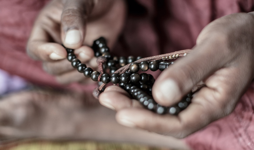 Hands holding prayer beads