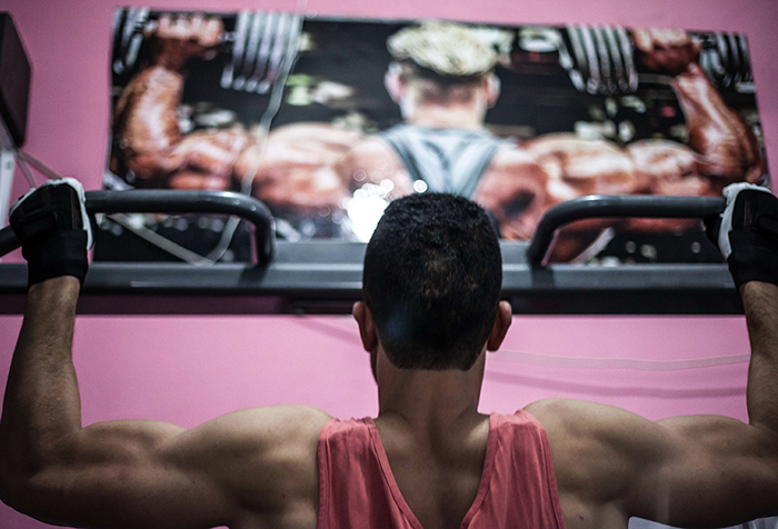 A young man with his back to the camera works out