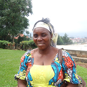 Borauzima wearing a blue and yellow dress with a white headband, smiling at the camera