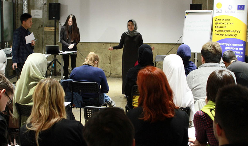 A woman gestures as she speaks at a meeting in Kyrgyzstan