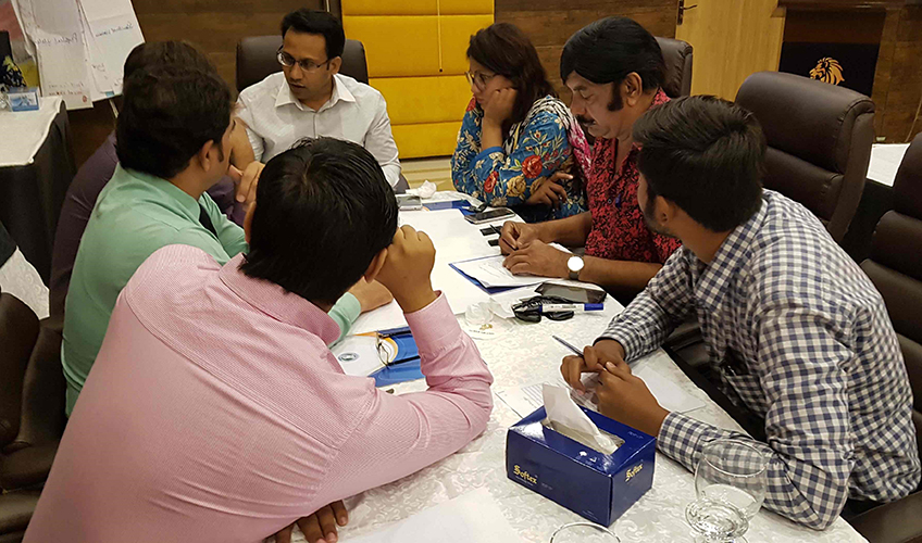 A group of men and a woman hold a meeting in Pakistan 