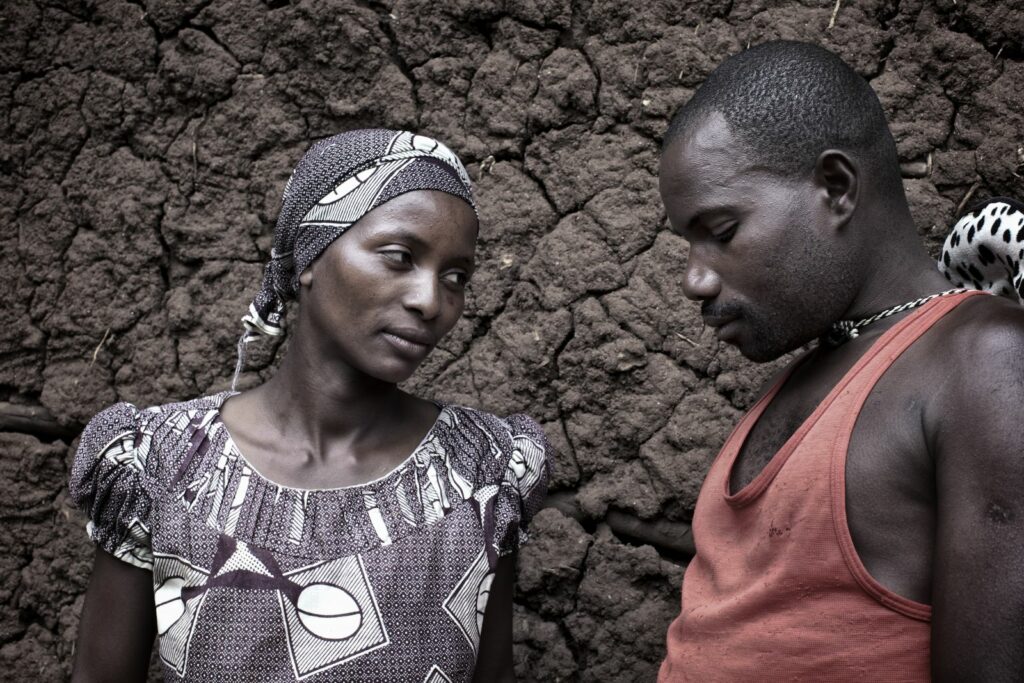 A middle aged woman glances left at a man