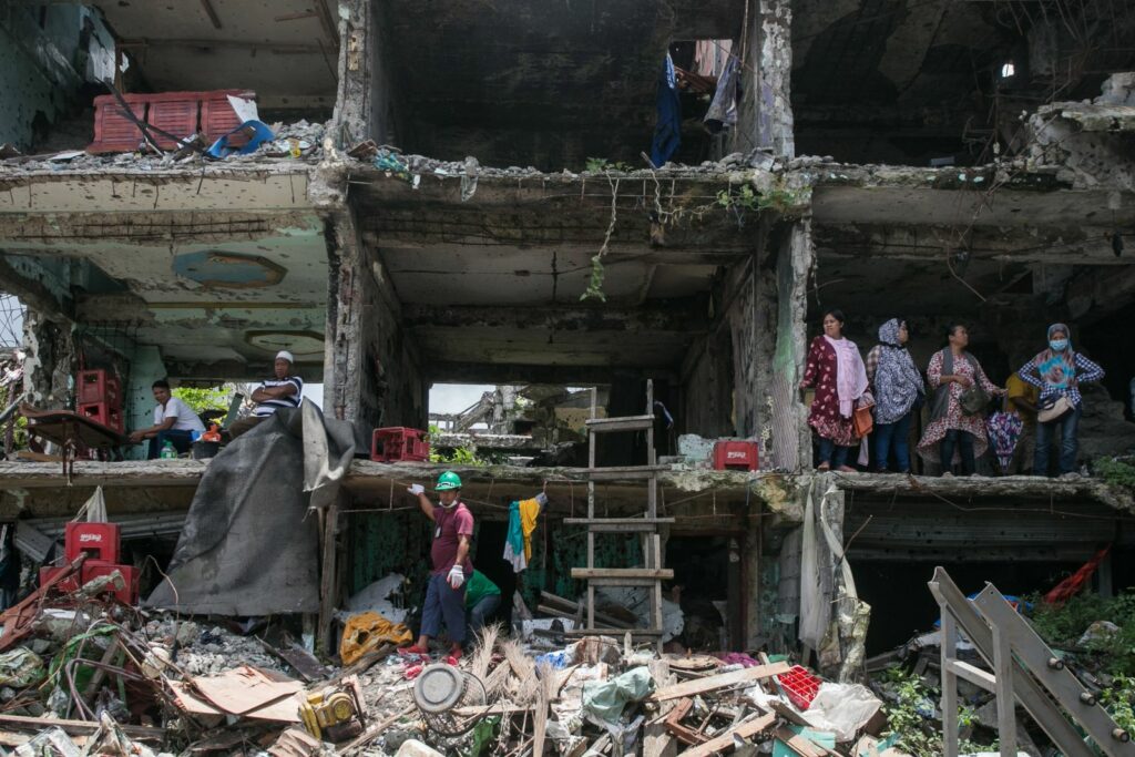 A rescue worker walks through the ruins of a building