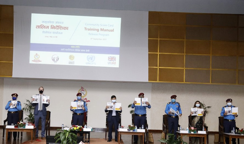 Nepal police officers hold up a training manual at an event
